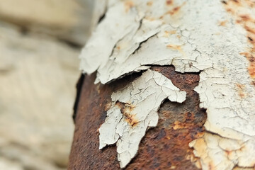 Peeling old paint from a metal pipe that has corroded. Chemical transformations in building...