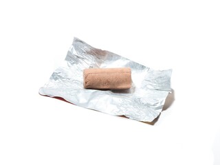 Chocolate candy on wrapper on isolated white background.