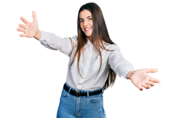 Young brunette teenager wearing business white shirt looking at the camera smiling with open arms for hug. cheerful expression embracing happiness.