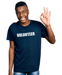 Young african american man wearing volunteer t shirt smiling positive doing ok sign with hand and fingers. successful expression.