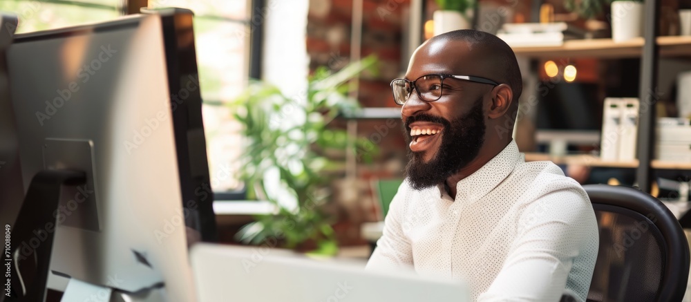 Aufkleber happy black businessman working as a customer service agent in an office, using a computer and crm s