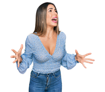 Young hispanic woman wearing casual clothes crazy and mad shouting and yelling with aggressive expression and arms raised. frustration concept.