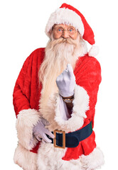 Old senior man with grey hair and long beard wearing traditional santa claus costume beckoning come here gesture with hand inviting welcoming happy and smiling