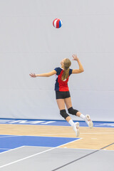 Teenage volleyball player serves.