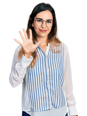 Beautiful hispanic woman wearing casual striped shirt showing and pointing up with fingers number five while smiling confident and happy.
