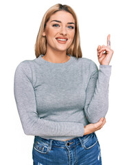 Young caucasian woman wearing casual clothes smiling happy pointing with hand and finger to the side