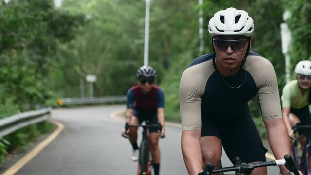 young asian cyclist training on rural road