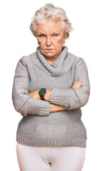 Senior grey-haired woman wearing casual winter sweater skeptic and nervous, disapproving expression on face with crossed arms. negative person.