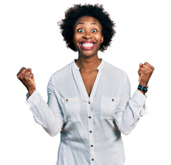 African american woman with afro hair wearing casual white t shirt celebrating surprised and amazed for success with arms raised and open eyes. winner concept.