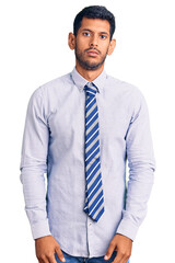 Young latin man wearing business clothes with serious expression on face. simple and natural looking at the camera.