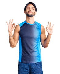 Handsome hispanic man wearing sportswear relax and smiling with eyes closed doing meditation gesture with fingers. yoga concept.