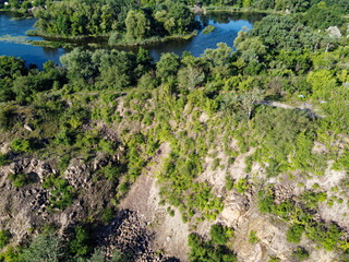 Rocky terrain overgrown with sparse vegetation, aerial view. Summer landscape from a bird's eye...
