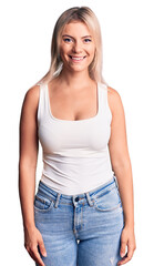 Young beautiful blonde woman wearing casual sleeveless t-shirt with a happy and cool smile on face. lucky person.