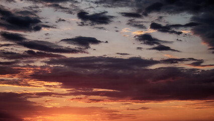 A beautiful sunset with the sun shining through dark clouds.