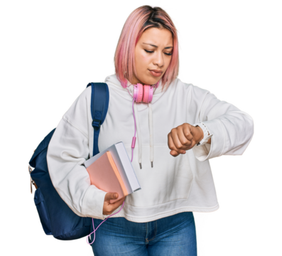 Hispanic woman with pink hair wearing student backpack and headphones checking the time on wrist watch, relaxed and confident