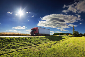 Fototapeta premium Large Transportation Truck on a highway road through the countryside at sunset