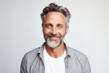 Smiling mature man with grey hair and beard. Studio shot.