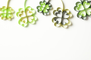 Green paper Patricks clover on white background. Happy St Patricks Day flat lay composition.