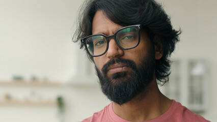 Muslim arabian indian multiethnic man in eyeglasses with serious worried sight portrait sad depressed bearded male in kitchen single lonely guy home renter homeowner pensive intelligent in glasses