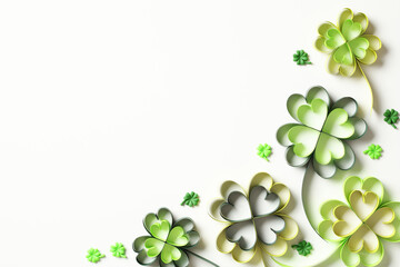 Green paper four leaf clover and confetti on white background. St Patricks Day banner design. Flat lay. Top view