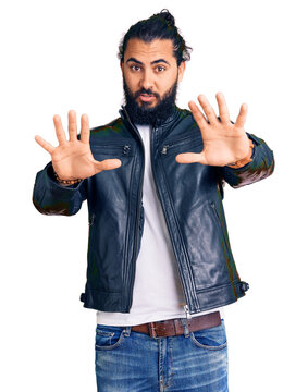 Young arab man wearing casual leather jacket doing stop gesture with hands palms, angry and frustration expression