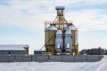 modern agro-processing plant for processing and silos for drying cleaning and storage of agricultural products, flour, cereals and grain in snow of winter field