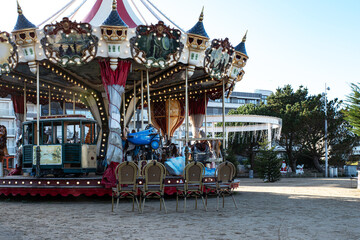 Chairs in front of a vintage wooden merry-go-round for children