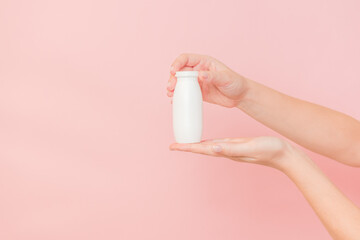 Hand holding bottle of probiotic yogurt for digestive system. Dietary supplements for stomach