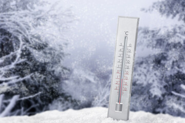Thermometer in snow showing temperature below zero outdoors on winter day