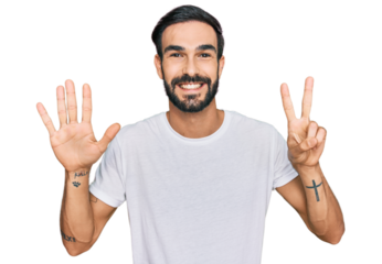 Young hispanic man wearing casual white t shirt showing and pointing up with fingers number seven while smiling confident and happy.