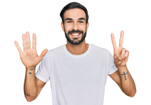 Young hispanic man wearing casual white t shirt showing and pointing up with fingers number seven while smiling confident and happy.