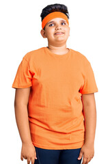 Little boy kid wearing sportswear looking away to side with smile on face, natural expression. laughing confident.
