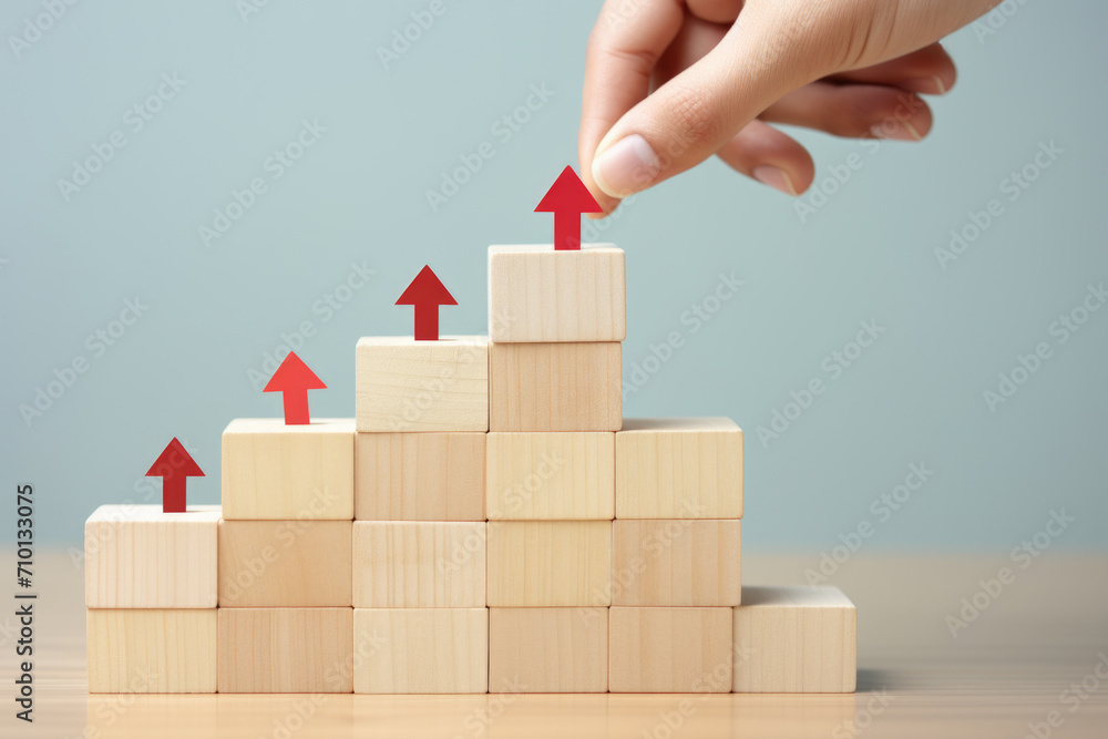 Poster hand is placing red arrow on stack of wooden blocks. this image can be used to represent direction, 