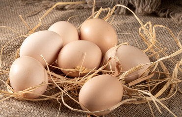 Fresh chicken eggs on rustic peasant table with burlap tablecloth