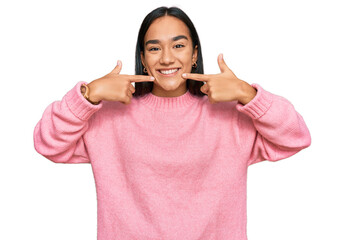 Young asian woman wearing casual winter sweater smiling cheerful showing and pointing with fingers teeth and mouth. dental health concept.