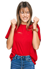 Teenager caucasian girl wearing casual red t shirt excited for success with arms raised and eyes closed celebrating victory smiling. winner concept.