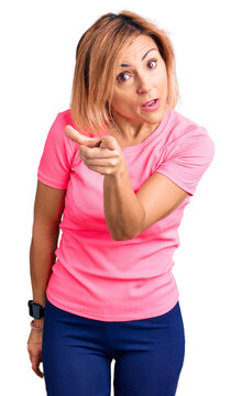 Young blonde woman wearing sportswear pointing displeased and frustrated to the camera, angry and furious with you