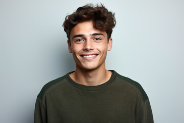 Young man with curly hair smiling at camera. Perfect for portraits and lifestyle images.