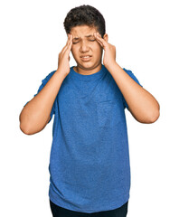 Teenager hispanic boy wearing casual clothes with hand on head for pain in head because stress. suffering migraine.