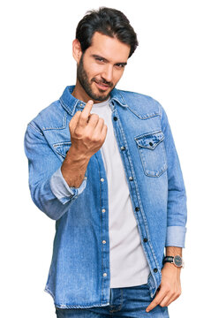 Young hispanic man wearing casual clothes beckoning come here gesture with hand inviting welcoming happy and smiling