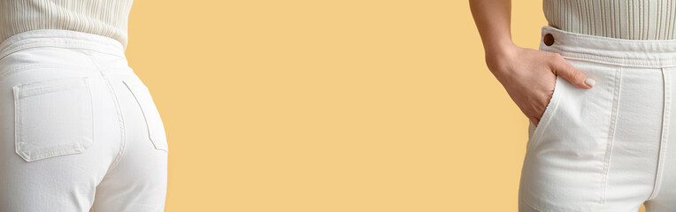 Young woman in white jeans on yellow background, closeup