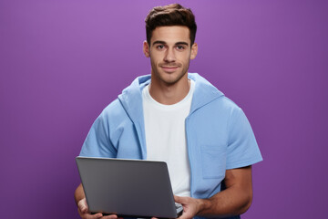 Man wearing blue hoodie holding laptop. Suitable for technology, work, or casual lifestyle themes.
