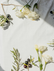 Olives and carnation flowers flat lay on soft off-white background, feminine authentic minimal...