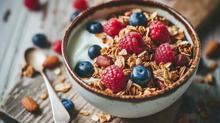 Fotobehang Delicious bowl of yogurt topped with fresh berries and crunchy granola. Perfect for healthy breakfast or snack. © vefimov