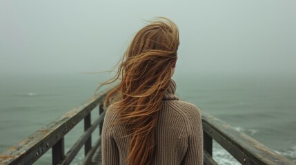 Fototapeta premium Back view of a woman with long hair, standing on a pier and looking out at a calm sea generative ai