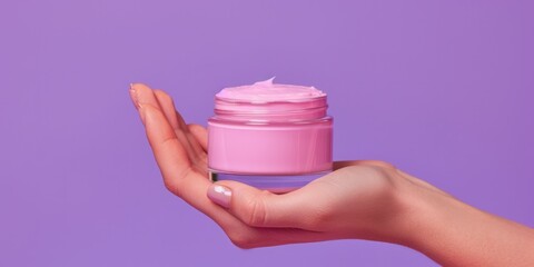A person holding a jar of pink cream. Perfect for skincare and beauty concepts