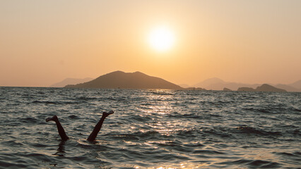 Sunset on the beach with the silouette of a person doing a handstand in the water, fun holiday pictures from Turkey