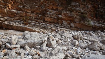 Eroded rocky cliff texture, photo of sandy rocks and dark brown color layered stone wall