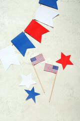 Fototapeta na wymiar USA flags, stars and garland on grey grunge background. Independence Day celebration
