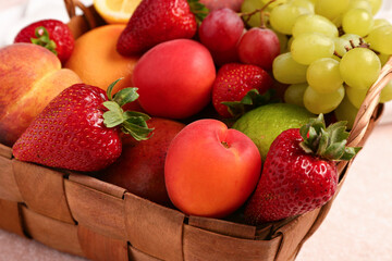 Wicker basket with different fresh fruits, closeup